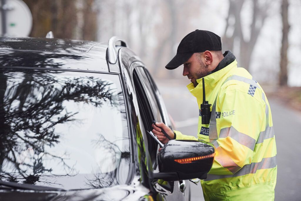 Police officer conducting a roadside check with driver, representing drug-impaired driving enforcement in Canada