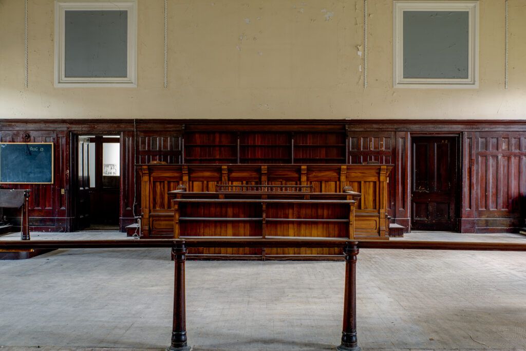 Empty courtroom with a judge’s bench and wooden jury box, representing jury duty obligations and penalties for ignoring a jury summons in Ontario.