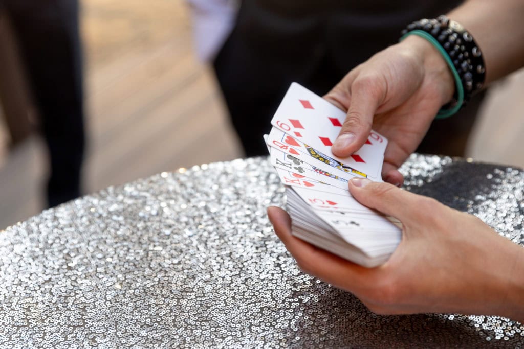 male hands holding playing card table silver