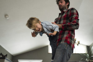 Father playing with son at home