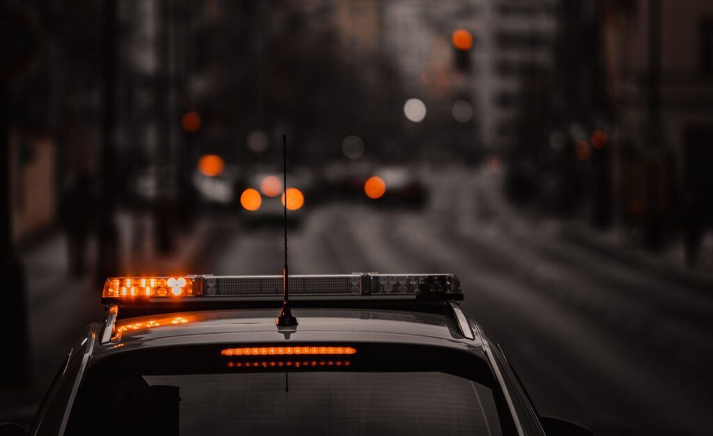 Police car with emergency lights on at night, representing a domestic assault call and police response to an alleged incident in Canada.
