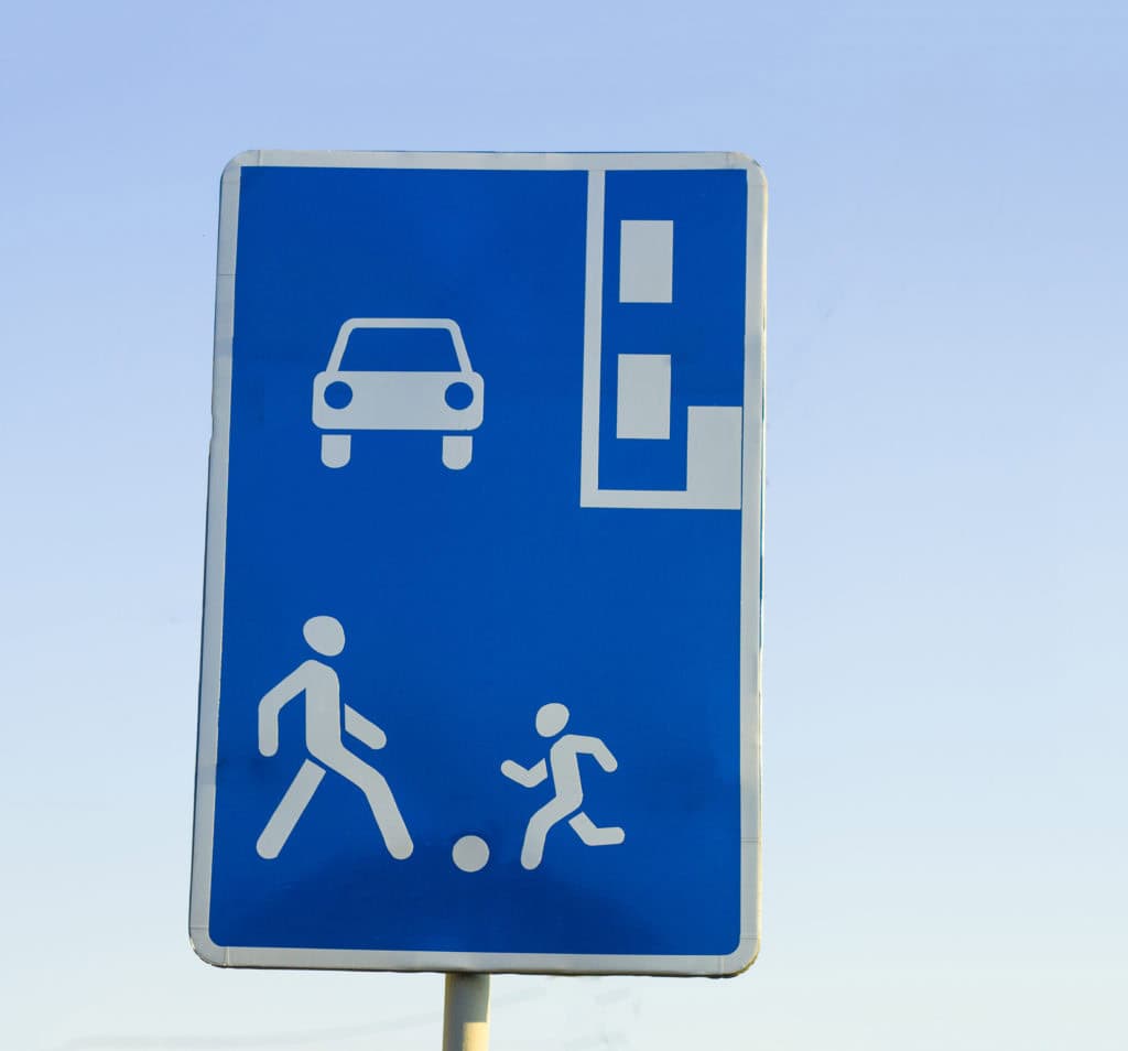 Information road sign, blue rectangular shield with human figures, car and parking marking. Attention, pedestrian zone recommendation.
