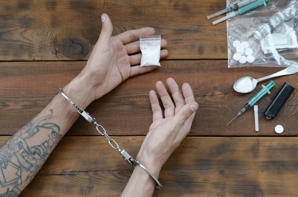 Drug traffickers were arrested along with their heroin. Police arrest drug dealer with handcuffs