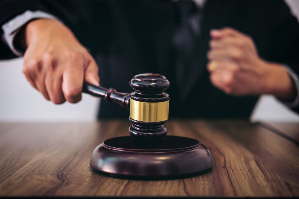 Close-up of a judge’s hand striking a gavel on a wooden block, symbolizing legal decisions and courtroom rulings in Canadian assault cases