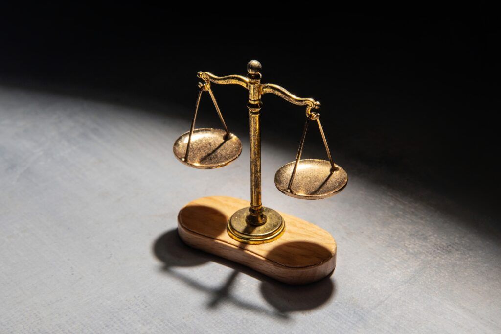 Scales of justice representing assault causing bodily harm charges, penalties, and possible defences under Canada’s Criminal Code.